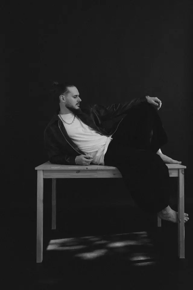 OPPAACHA lying across a wooden table in a dark studio