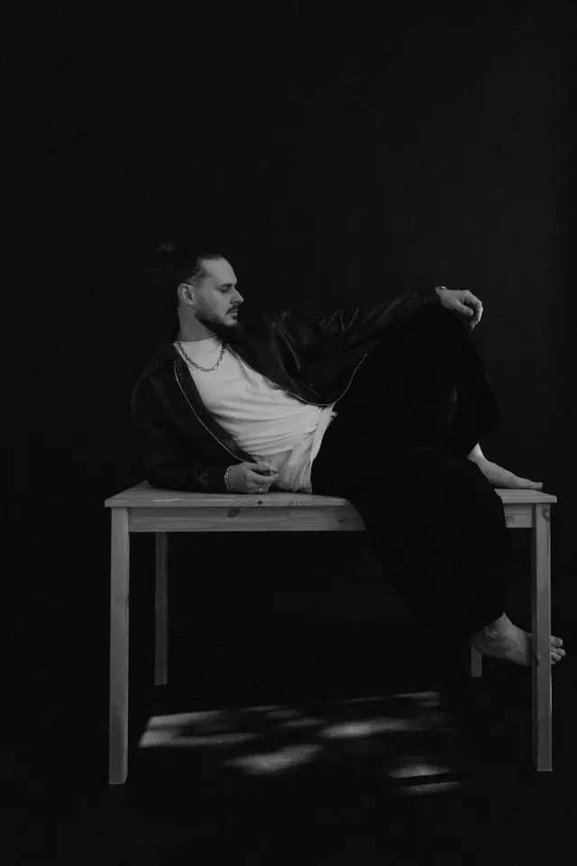 OPPAACHA lying across a wooden table in a dark studio